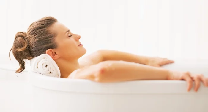 A warm bath is one of the good ways to relax your muscles before bed and ease the pain. 